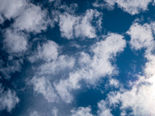 Bright Blue Sky with Scattered White Clouds and Sunlit Patch