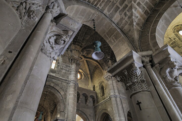 Matera, Italy. Vault and stone columns of the Church of San Giovanni Battista in the Sassi of Matera, Italy. Romanesque architecture with sculpted capitals and stained glass windows.