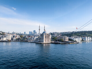 Obraz premium Aerial view of Ortaköy Mosque on embankment of Bosphorus with cityscape on sunny day, Istanbul, Turkey
