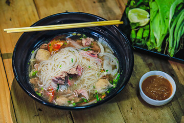 Pho, A hearty and flavorful noodle dish, typical of Southeast Asian cuisine, featuring a rich...