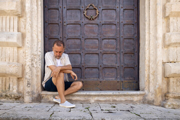 Man between 55 and 60 years old posing for the camera. Adult man wearing modern clothes.