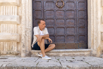 Man between 55 and 60 years old posing for the camera. Adult man wearing modern clothes.