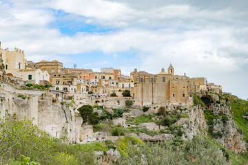 Matera, Italy. Scenic view of the Convento di Sant'Agostino and the historic center of the Sassi di Matera, Italy, with ancient stone buildings perched above the Murgia valley. 
