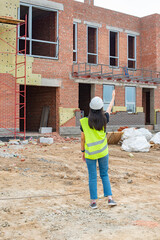 Fototapeta premium One girl in overalls came to the construction site. High quality photo