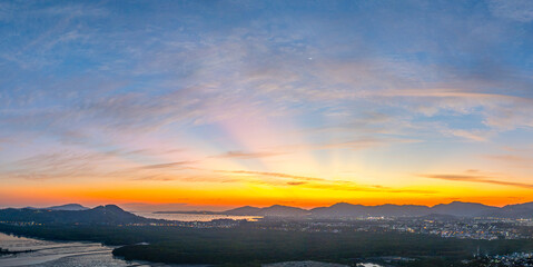 A stunning panoramic view of a coastal city at sunset at Phuket city, showcasing vibrant hues of...