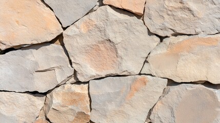 Close-up view of a stone wall, showing various light beige and gray stones