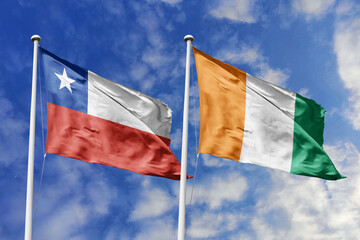 Flags of Chile and Ivory Coast Waving Together Under a Bright Blue Sky, Symbolizing Diplomatic...