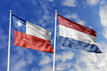 Flags of Chile and the Netherlands Waving Proudly Against a Blue Sky, Symbolizing International Alliance and Friendship