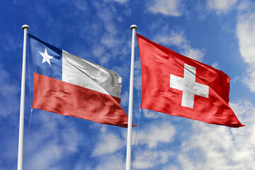 Chile and Switzerland flags waving under a bright sky, symbolizing unity and ties. Red, white star...