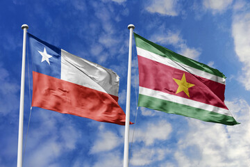 Chile and Suriname flags waving under a bright sky, symbolizing unity and ties. Red, white star of...