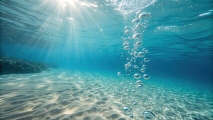 Underwater scene with sunlight and bubbles over sandy ocean floor  