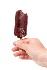 Hand holding a chocolate popsicle showcasing a frozen treat against a white background