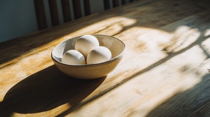 White eggs in bowl on wooden table with sunlight for rustic kitchen breakfast minimal food styling