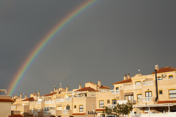 Stunning rainbow arches over residential buildings in Spain after rain shower