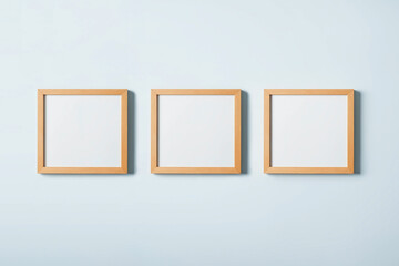 Blank picture frames on blue wall background. Stylish wooden photoframes
