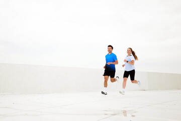 Joyful joggers race across a sunlit rooftop, embracing the invigorating spirit of fitness and freedom in the early morning light