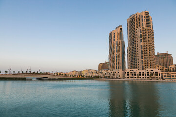 Obraz premium Doha, Qatar - 13 June 2025: A scenic view of vibrant residential buildings along the coast of The Pearl Island in Doha, Qatar the image shows colorful architecture, calm sea water