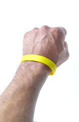 Yellow wristband on hand, white background