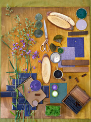 Flat lay of a creative moodboard composition featuring natural materials, fabric swatches, forest...