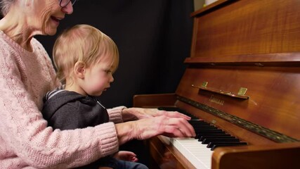 Grandmother and toddler play piano together in a cozy indoor setting, capturing family warmth, music education, and the beauty of cross-generational bonding. - Powered by Adobe