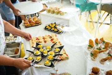 Beautifully arranged catering table with assorted finger foods, fruit platters, mini sandwiches, and desserts, perfect for weddings, receptions, and upscale events.