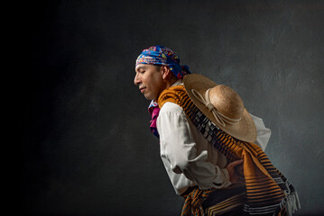 A man wearing a hat and a scarf is walking