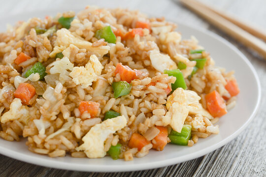 Homemade vegetarian fried rice made with onion, white cabbage, carrot, green pepper, soy sauce, oyster sauce, sesame oil and scrambled eggs (Selective Focus, Focus in the middle of the image)