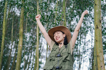 Joyful girl celebrating in a lush forest during a sunny day