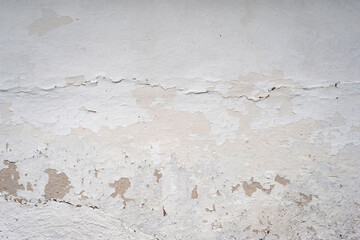 Old clay wall. Cracked plaster of a rural house
