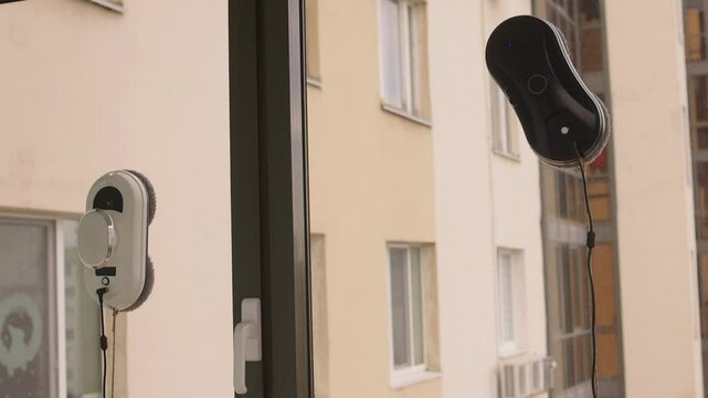 A man uses an automatic window cleaner for sparkling, crystal-clear glass and a spotless finish