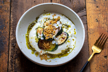 Burrata with pesto, grilled courgettes, crispy garlic breadcrumbs and radish flowers