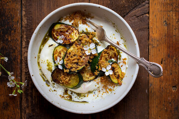 Burrata with pesto, grilled courgettes, crispy garlic breadcrumbs and radish flowers