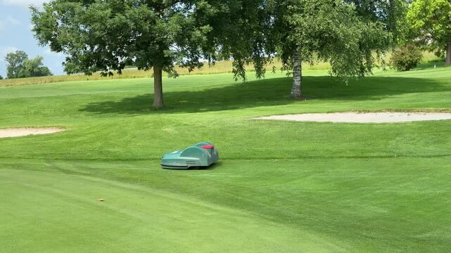 lawn robot mowing green and fairway on golf course - Powered by Adobe
