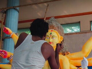 Bangladesh, June 15 2023- A pottery artist paints the eye on a clay idol of Hindu Goddess Durga...