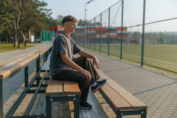 Alone Teen Boy on Sports Bleachers Lost in Thought and Reflection