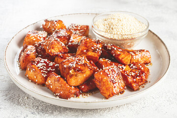 fried pieces of salmon teriyaki with sesame seeds, top view,