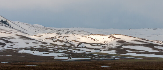 Icelandic landscape with mountains and meadow land covered in snow at snaefellsnes peninsula in...