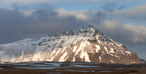 Icelandic landscape with mountains and meadow land covered in snow at snaefellsnes peninsula in...