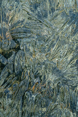 needles and crystals of melting transparent ice on the pebble shore of the northern Kolyma