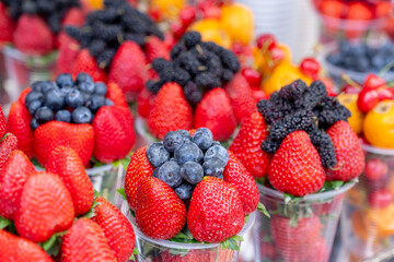 Assorted containers of berries for sale at a market. Fruits