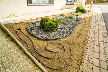 spring flowerbed behind auto-watering near one of the houses in Italy