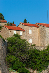 Fototapeta premium A fragment of the stone medieval fortress of Sveti Stefan island-hotel, on the Adriatic coast, Montenegro. Details. Vertical