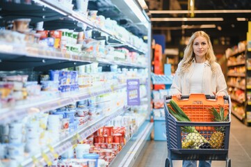 Young woman doing grocery shopping at the supermarket