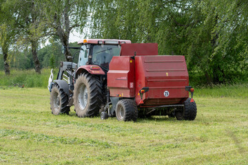 Modern Tractor with Hay Baler Working in Green Field – Agricultural Machinery Concept