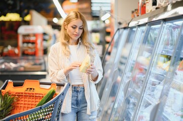 Woman choosing cheese in grocery store