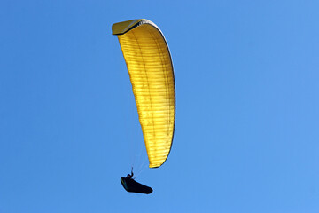 Paraglider flying in a blue sky	