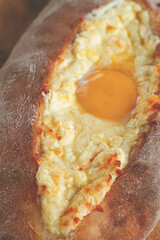 Freshly baked Adjarian khachapuri with beaten egg, traditional Georgian cuisine, homemade, natural...
