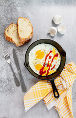 Freshly cooked eggs in a pan, served with bread, on the kitchen counter,breakfast, natural light, no people,