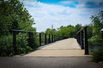 close-up of a pedestrian and bike trail bridge with metal rails and lush greenery in Wausau, Wisconsin