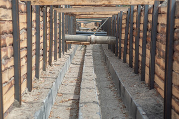 Pipe crossing inside a reinforced trench during the installation of utility lines beneath a city...